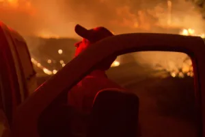 man in fire by car