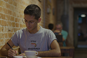  College student writing in coffee shop