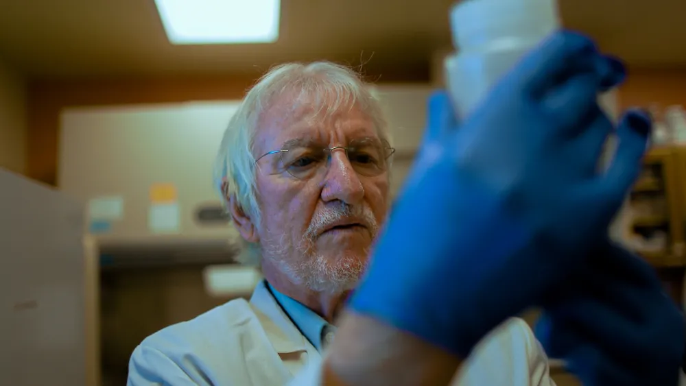 Scientist holding up and looking at a sample
